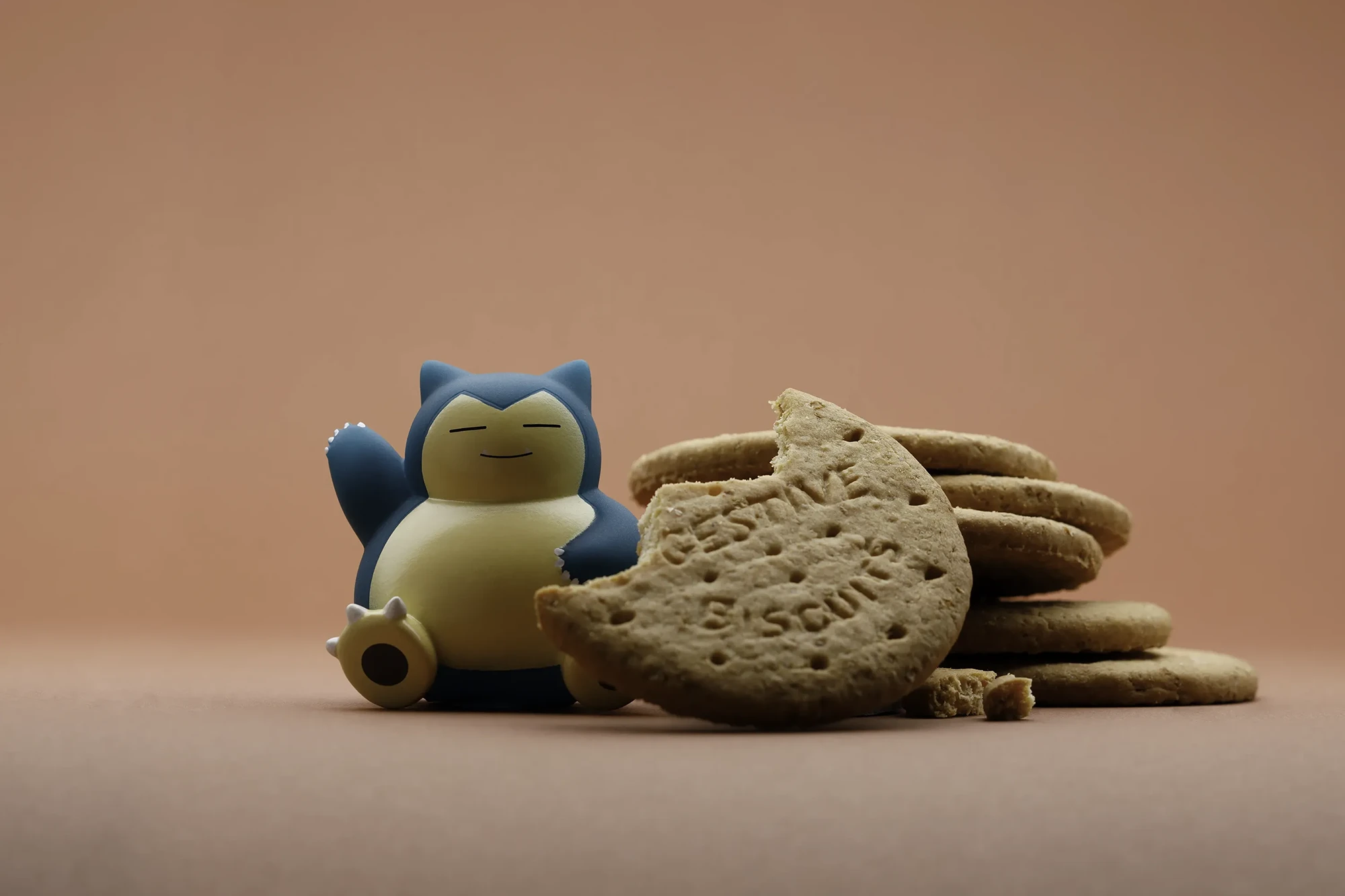 immagine stile pop di action figure Pokemon Snorlax - immagine realizzata seguendo l'idea del personaggio e della sua personalità, integrando nell'immagine dei biscotti si è riusciti a dare al personaggio vita e ambientarlo, il tutto realizzato in studio fotografico per aziende