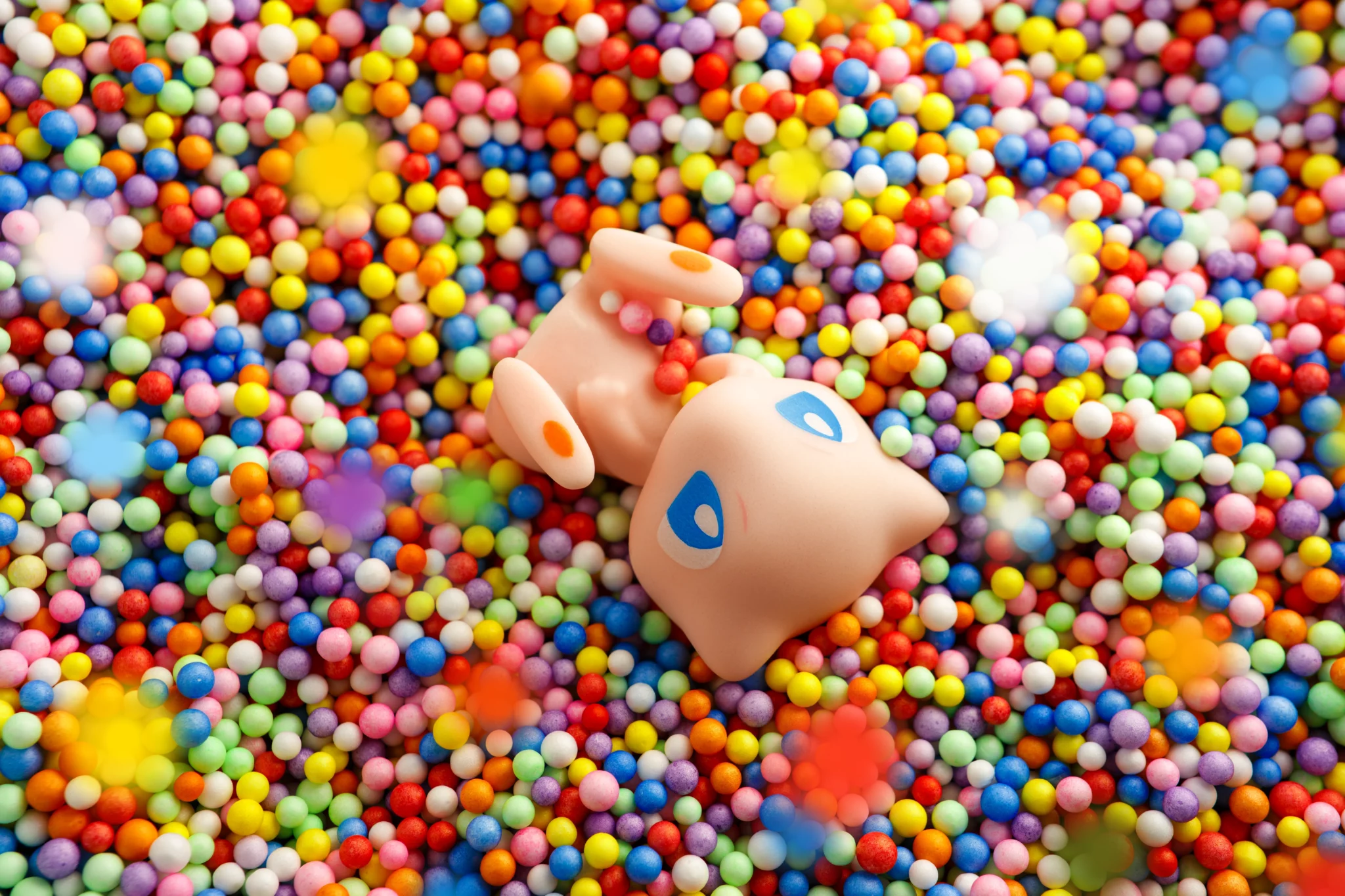 immagine stile pop di action figure Pokemon Mew - immagine realizzata seguendo l'idea del personaggio e della sua personalità, tramite l'uso di sfere in polistirolo colorate si è creata un immagine che rappresenti il personaggio, il tutto realizzato in studio fotografico per aziende